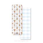 Christmas bookmark with gingerbread Elaine Girls characters and bows on a blue gingham background
