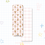 Christmas bookmark with gingerbread Elaine Girls characters and bows on a pink gingham background