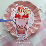 Strawberry Shake jumbo vinyl sticker featuring a pink strawberry milkshake topped with strawberries, whipped cream, two straws, and a cookie by Elaine Girls