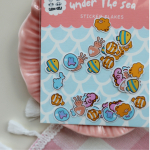 Under the Sea sticker flakes featuring colorful fish, shells, and cute ocean creature illustrations by Elaine Girls