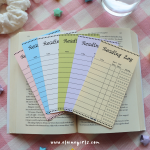 Colorful reading log bookmarks displayed on an open book, with spaces to track titles, reading dates, and star ratings by Elaine Girls