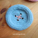 Light blue handmade crochet button coaster with pink stitched button detail by Elaine Girls